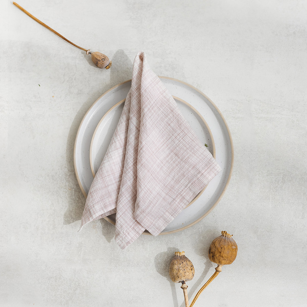 Set of two 100% linen napkins, neatly folded on a neutral table surface.