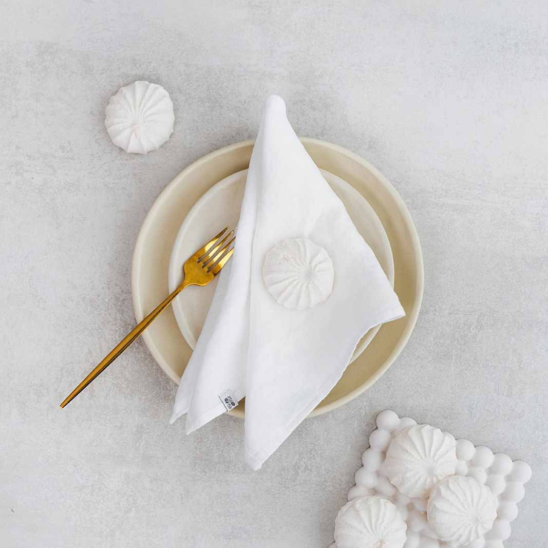 Set of two 100% linen napkins, neatly folded on a neutral table surface.