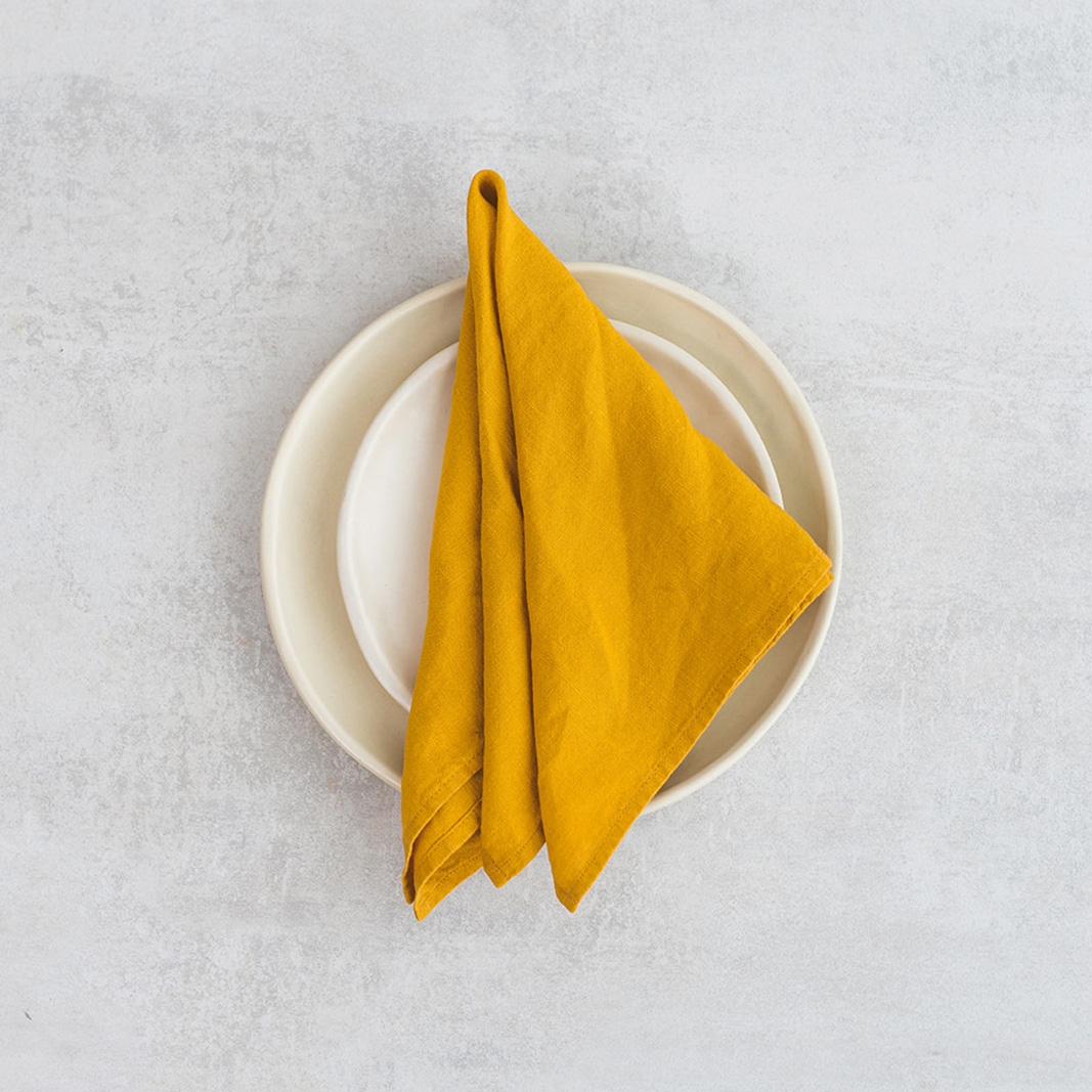 Linen napkin Mustard Set of two 100% linen napkins, neatly folded on a neutral table surface.