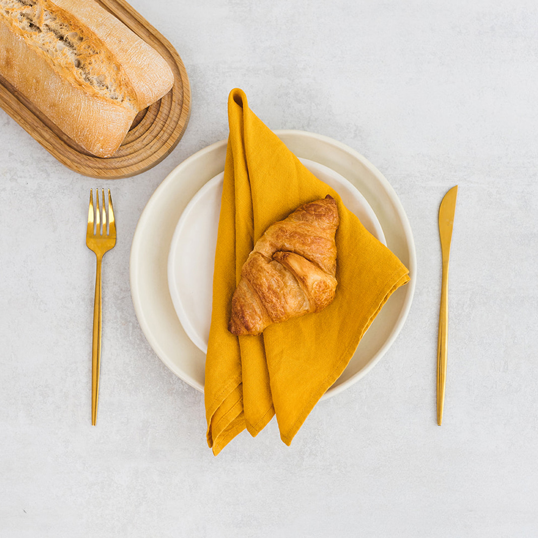 Linen napkin Mustard Set of two 100% linen napkins, neatly folded on a neutral table surface.