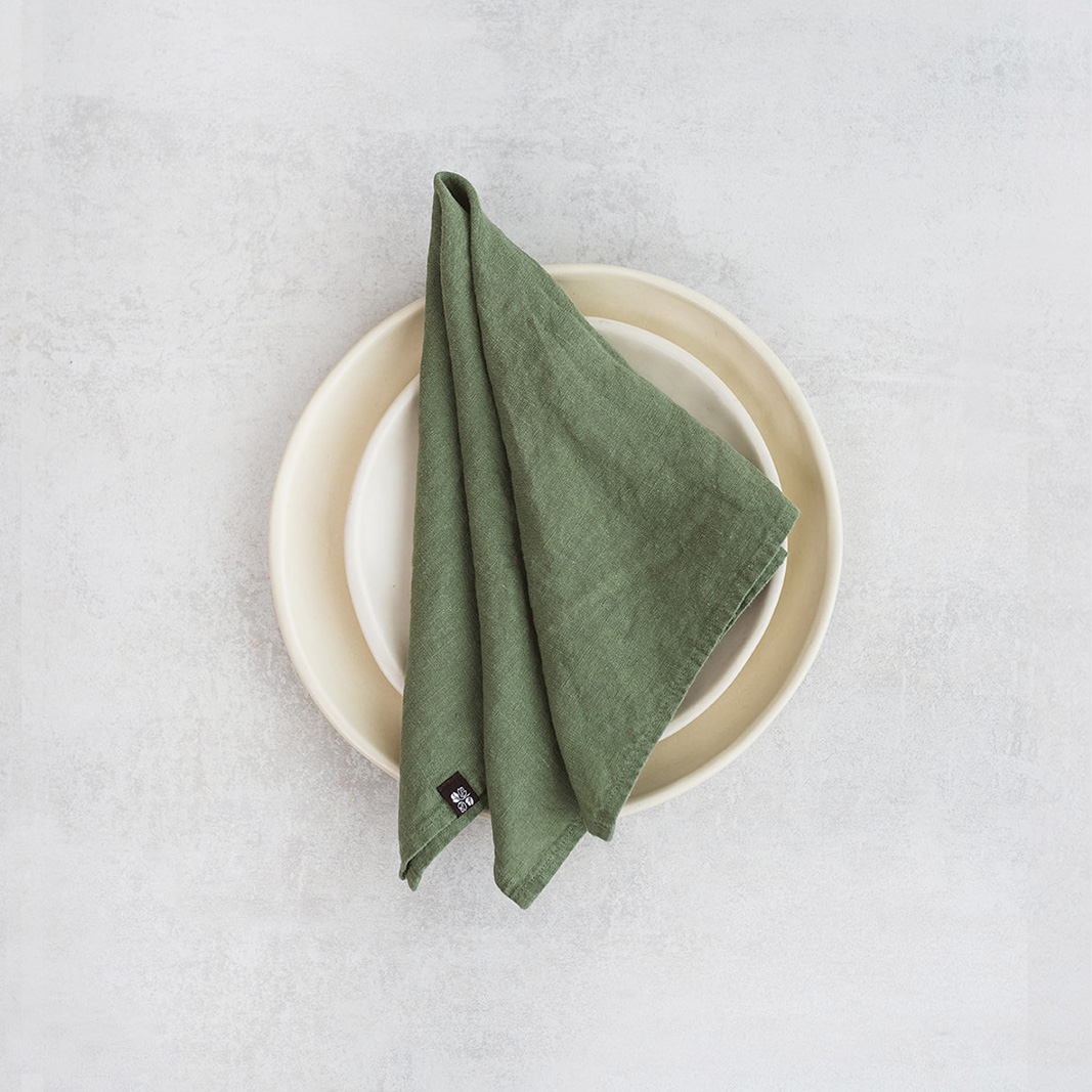 Linen napkin Deep moss Set of two 100% linen napkins, neatly folded on a neutral table surface.