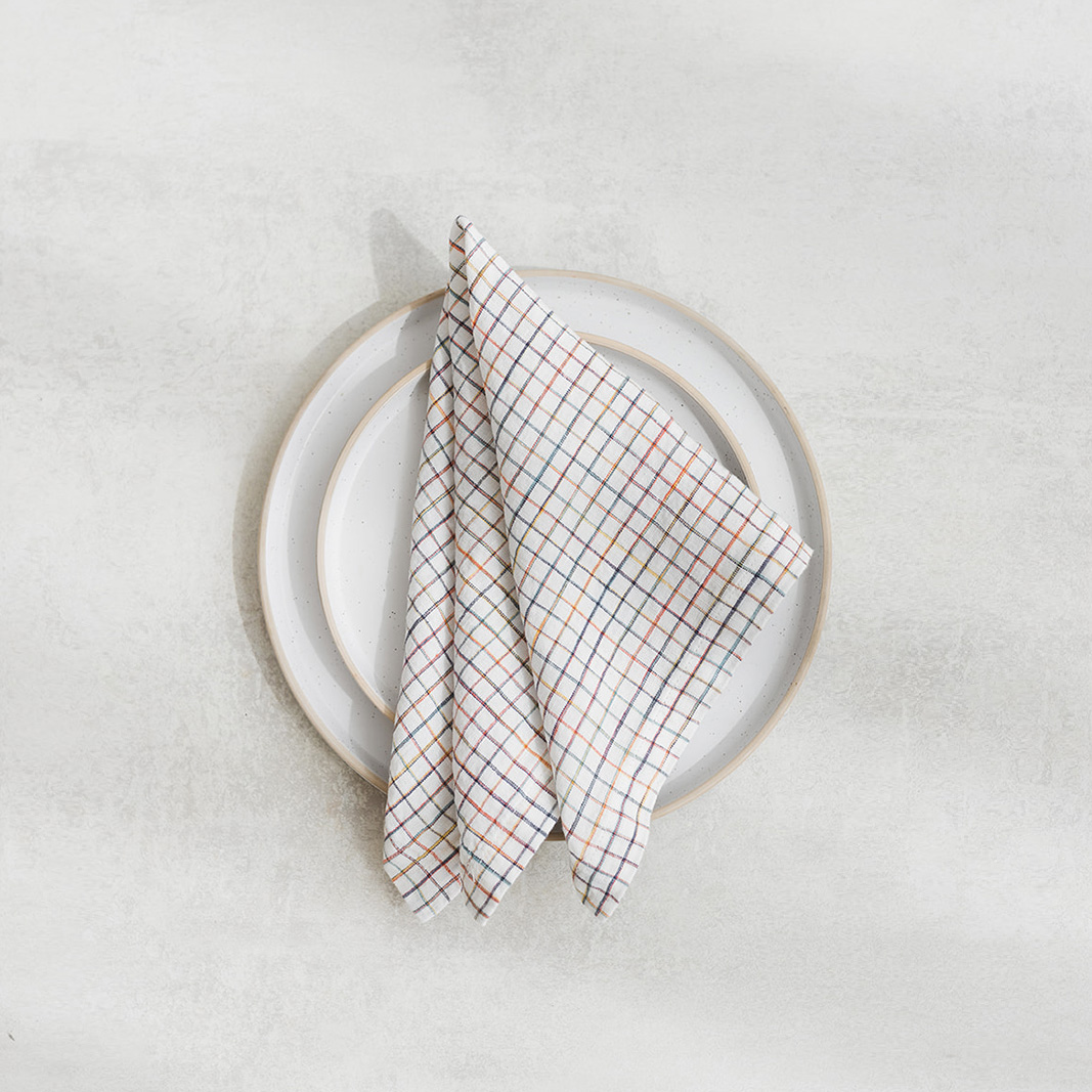 Set of two 100% linen napkins, neatly folded on a neutral table surface.