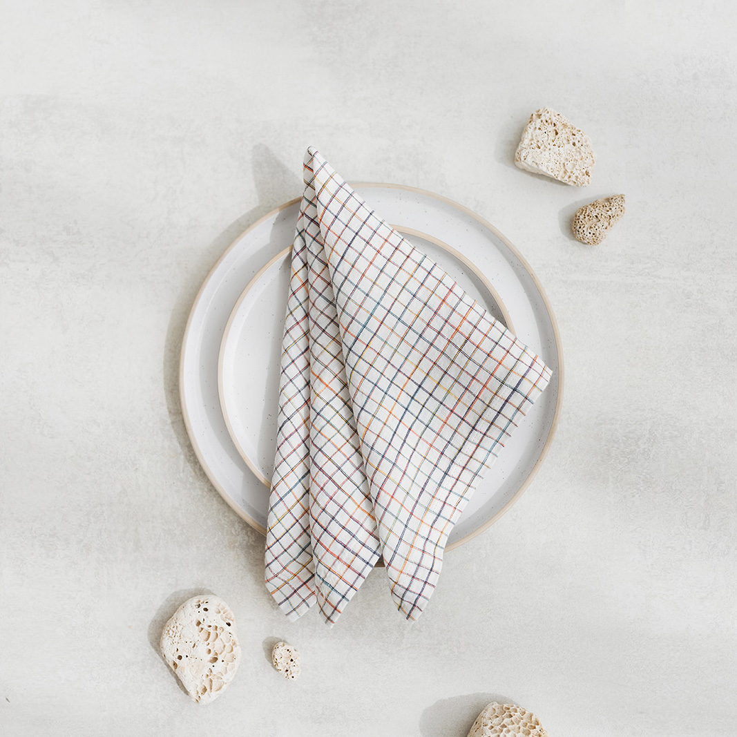 Set of two 100% linen napkins, neatly folded on a neutral table surface.